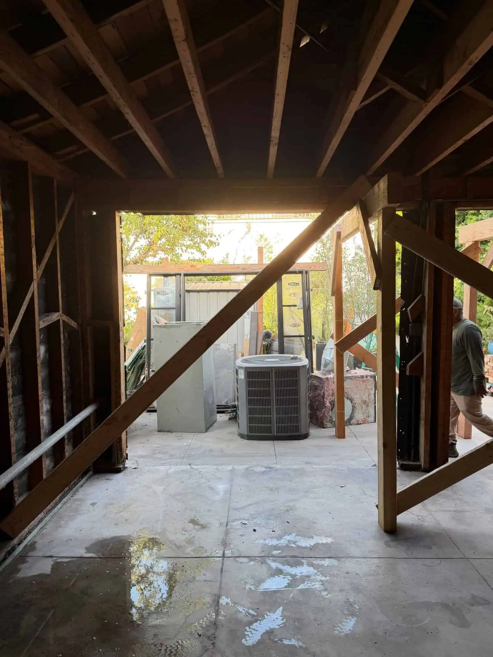View from inside a building under construction showing framing and outdoor equipment.