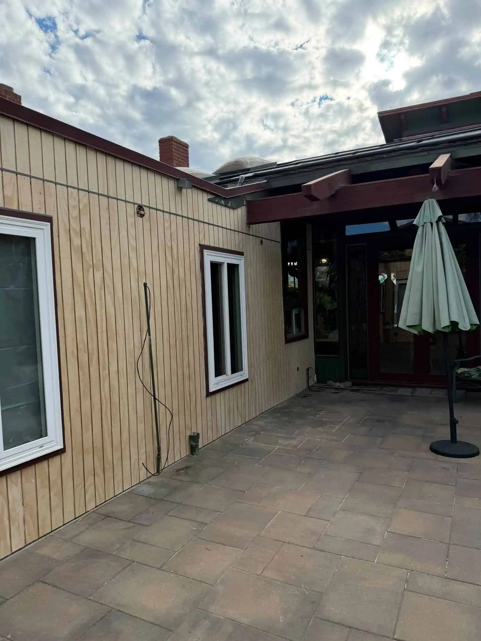 Exterior view of a building with wooden siding and patio area by D/J Construction Inc.