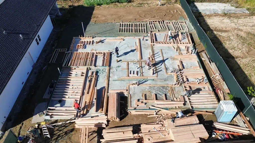 Construction site with wooden framework for building foundation by D/J Construction Inc.
